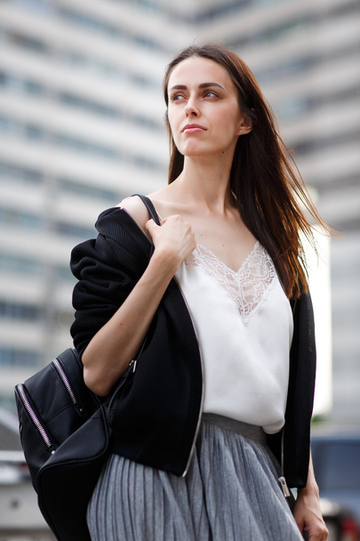 Outdoors portrait of brunette woman with bag on right shoulder - Foto, afbeelding