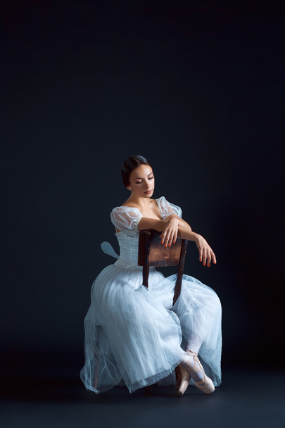 Portrait of the classical ballerina in white dress on black background - Foto, Imagen