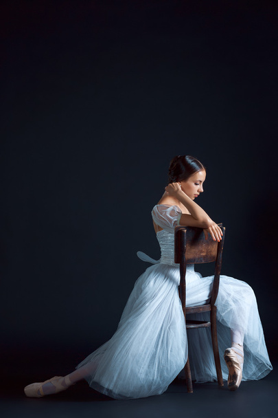 Portrait of the classical ballerina in white dress on black background - Foto, Imagen