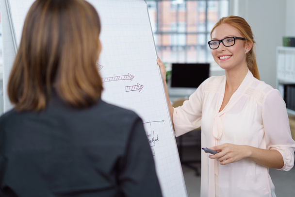 Happy young businesswoman talking to a colleague - Photo, Image