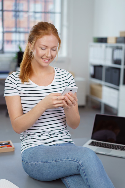 Attractive happy young woman reading an sms - Photo, Image