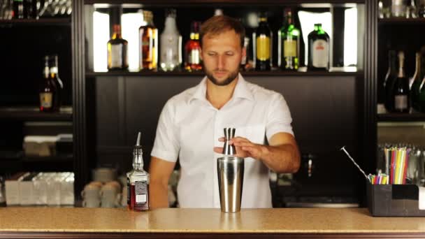 Barman gieten inhoud van jigger en giet in shaker bereidt alcoholische cocktail - Video
