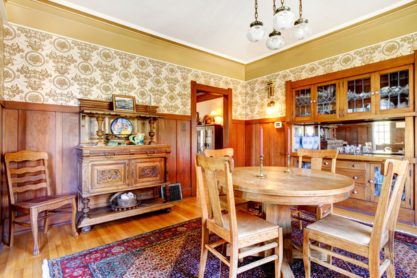 Open floor plan antique dining area with wooden panel trim - Foto, Imagen