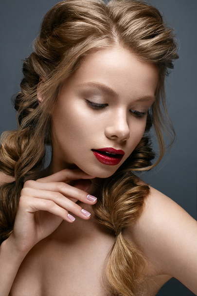 Beautiful girl with braids and gentle makeup. Nude. Beautiful model with bright red lips - Photo, Image