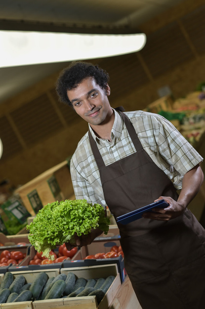 Grocery store employee reading inventory list on digital tablet - Photo, image
