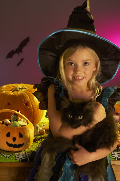 Halloween party with a child holding black cat in hand - Foto, Bild