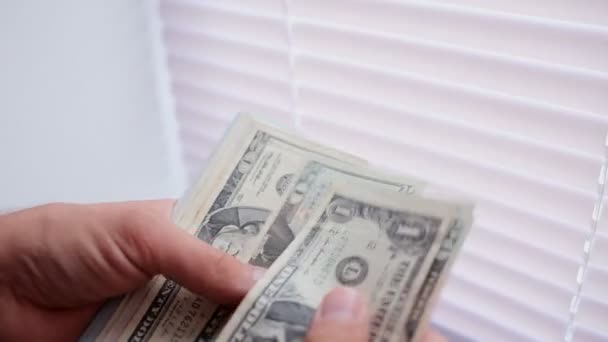Primer plano de un empresario manos contando billetes de cien dólares en una mesa
 - Metraje, vídeo