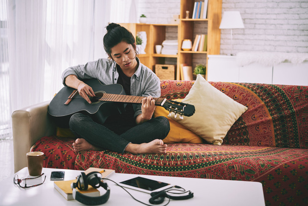 man playing guitar at home - Foto, afbeelding