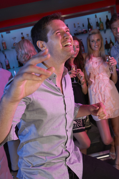 Young Man Having Fun In Busy Bar - Foto, immagini