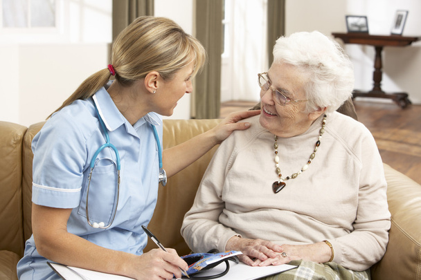 Senior Woman In Discussion With Health Visitor At Home - Foto, Imagem