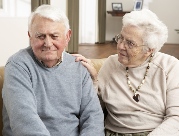 Senior Woman Consoling Husband At Home - Foto, Imagen