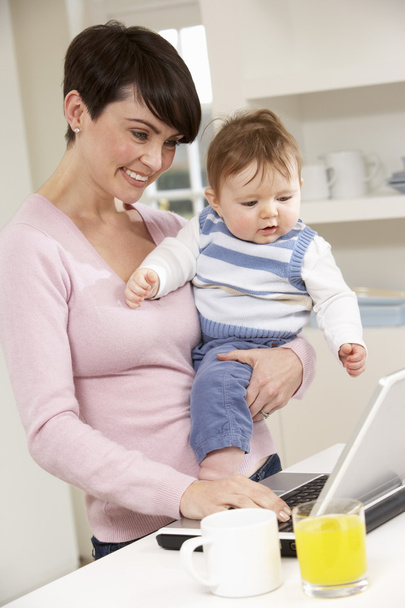 Woman With Baby Working From Home Using Laptop - Photo, image
