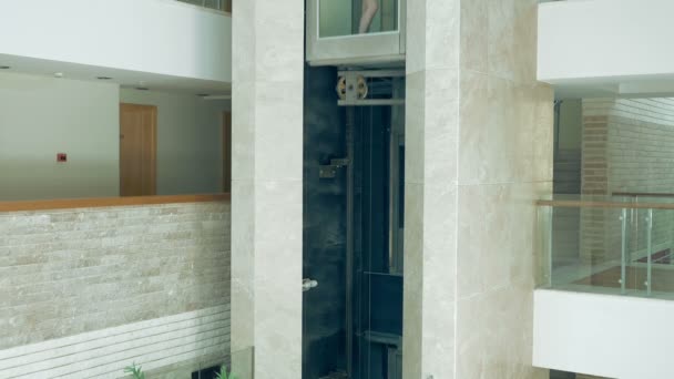 Uma fêmea está de pé no elevador em movimento de vidro
 - Filmagem, Vídeo