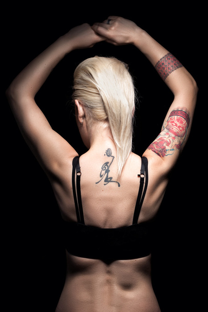 dos de punk blonde femelle avec tatouage et perçage et coupe de cheveux courte
 - Photo, image