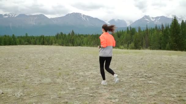Senior vrouw maakt zich klaar joggen rond de tarn in prachtige bergen. - Video
