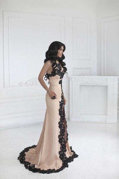 Beautiful fashion brunette woman in elegant dress with long wavy - Foto, afbeelding