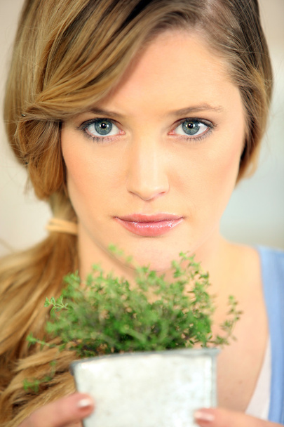 Pretty young woman holding plant - Fotografie, Obrázek