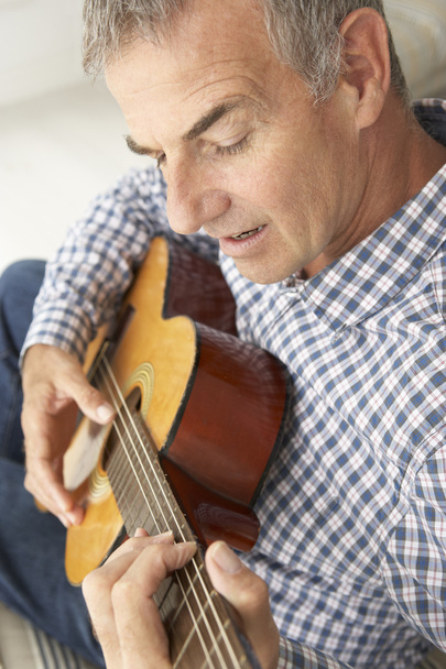 Mid age man playing acoustic guitar - Fotoğraf, Görsel