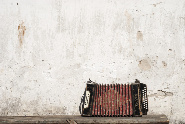 стены и аккордеона на фоне скамейки
 - Фото, изображение