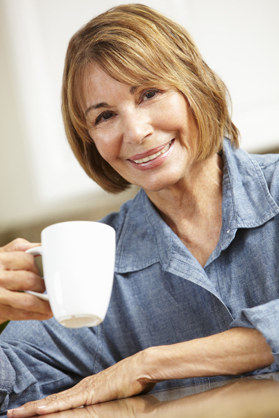 Mid age woman drinking coffee - Фото, изображение