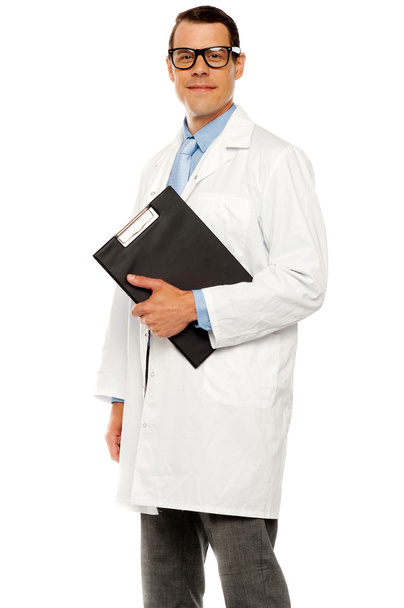 Doctor in glasses carrying clipboard - Zdjęcie, obraz