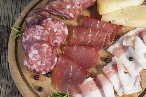 Primo piano su tagliere di prodotti tradizionali italiani con salame, affettati e formaggio  - Foto, Imagem