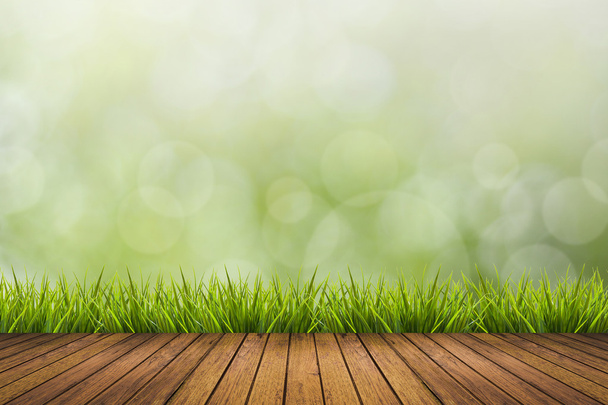 Wooden floor, grass and green blurred background - Photo, Image