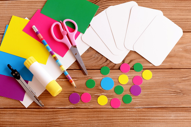 Κομμένα φύλλα και κύκλο, ψαλίδι, μολύβι, κόλλα, έγχρωμα φύλλα χαρτιού σε ένα ξύλινο τραπέζι. Πώς να κάνει εκπαιδευτικά flashcards από χαρτόνι για την διδασκαλία των παιδιών. Το Top view. Φροντιστήριο. Βήμα  - Φωτογραφία, εικόνα