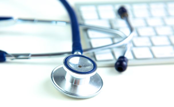 stetoscopio medico vicino al laptop su tavolo di legno, bianco
 - Foto, immagini