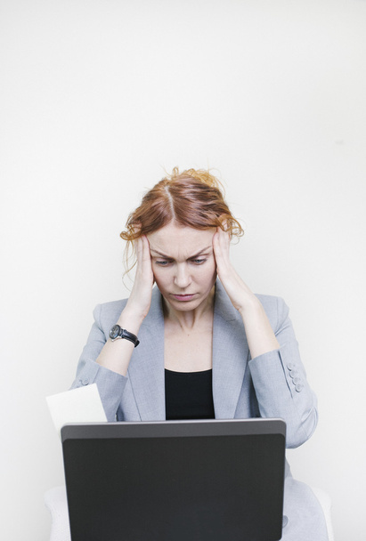 Stressed business woman sitting in front of her laptop - Foto, Imagen