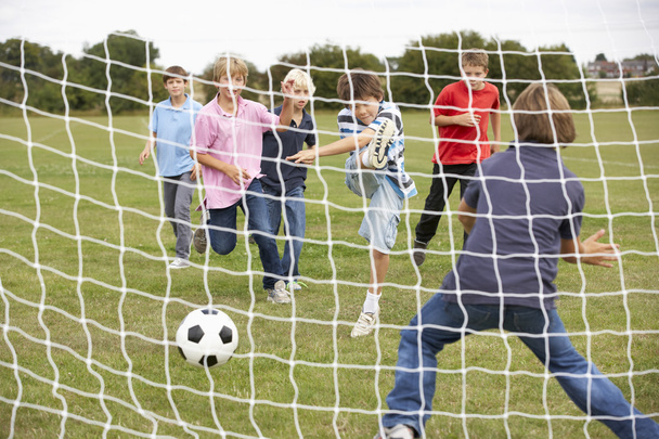 Boys playing soccer in park - Fotó, kép