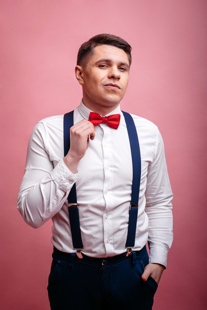 young stylishly dressed man straightens his bow tie - Zdjęcie, obraz