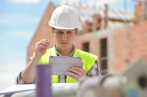 Foreman using digital tablet on construction site - Foto, immagini