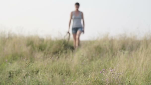 Young woman with dog in the nature. Girl walking a terrier in a field. Walking with a dog in the countryside.  - Filmmaterial, Video