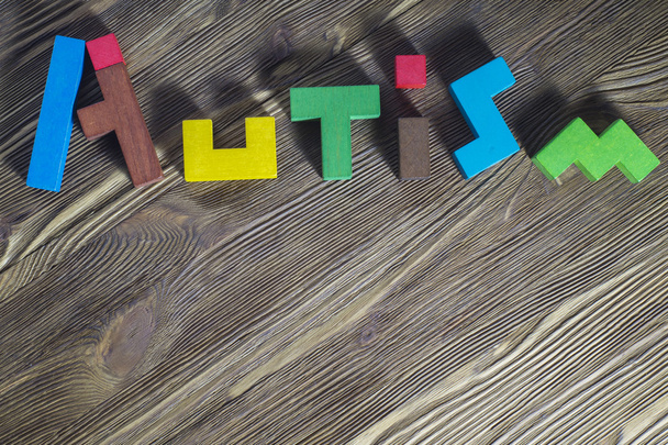 Parola Autismo costruito di puzzle di legno su uno sfondo di legno
. - Foto, immagini