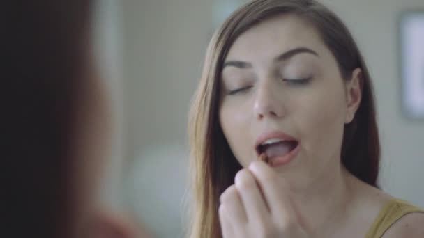 Woman applying lipstick in mirror - Materiał filmowy, wideo
