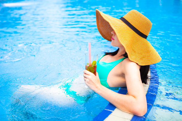Beautiful brunette woman in bikini and hat, enjoying mojito cock - Foto, Bild