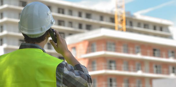 Foreman using walkie-talkie on construction site - Fotó, kép