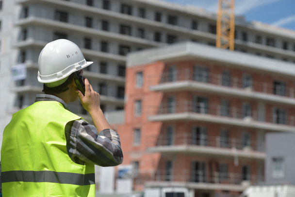 Foreman using walkie-talkie on construction site - Valokuva, kuva