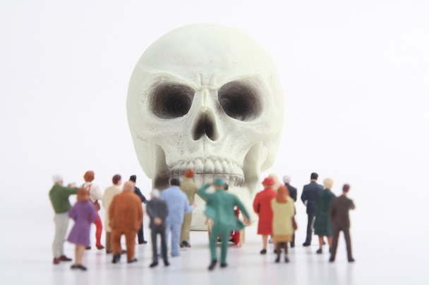 miniature figurines crowd of people and skull - Photo, Image