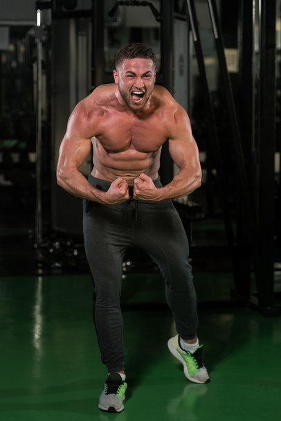 Handsome Body Builder Making Most Muscular Pose - Foto, Bild