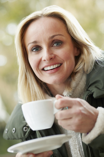 Woman In Outdoor Café With Hot Drink Wearing Winter Clothes - Photo, image