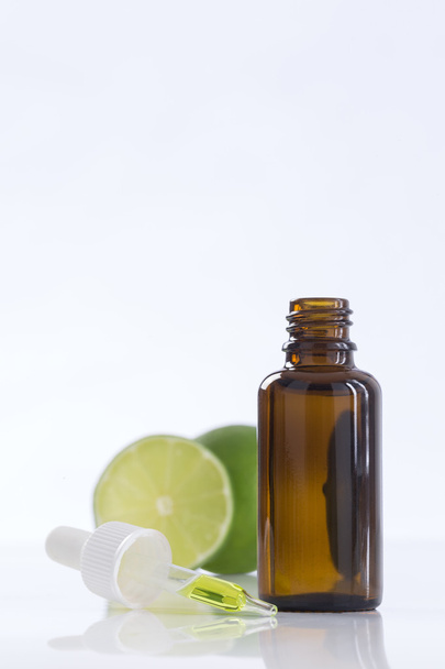 Aromatherapy essential oil bottle with lime - Фото, изображение