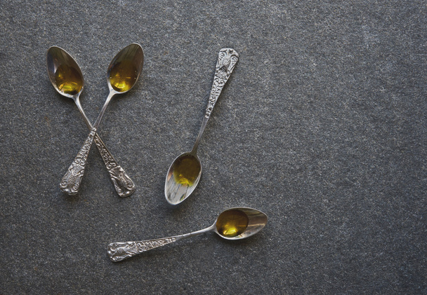 Olive oil in vintage spoons - 写真・画像