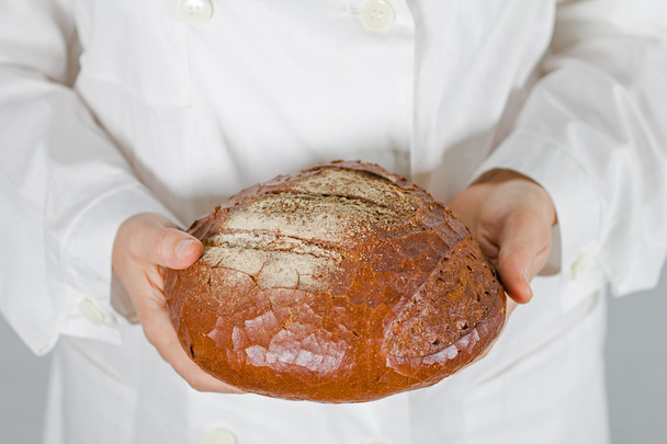Baker sosteniendo pan fresco en las manos de
 - Foto, Imagen
