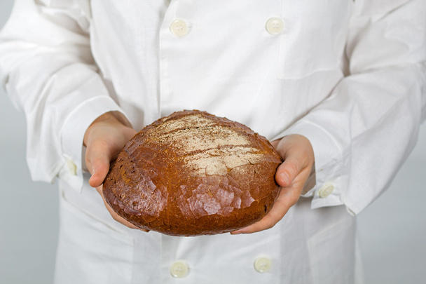 Baker sosteniendo pan fresco en las manos de
 - Foto, Imagen