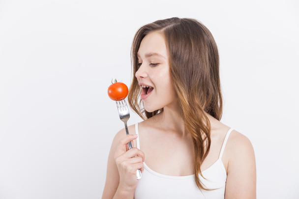 Girl biting tomato - Fotoğraf, Görsel