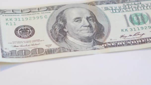 Billete de dólar girando sobre un fondo blanco
 - Imágenes, Vídeo