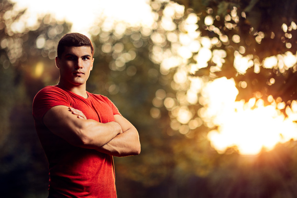 Όμορφος αθλητικός άνδρας στέκεται έξω στη φύση - Φωτογραφία, εικόνα