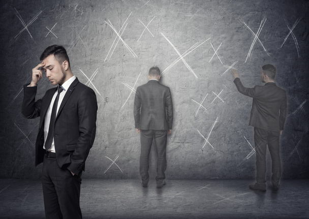 Image of businessman thinking about how to solve problem with x marks around him - Photo, image